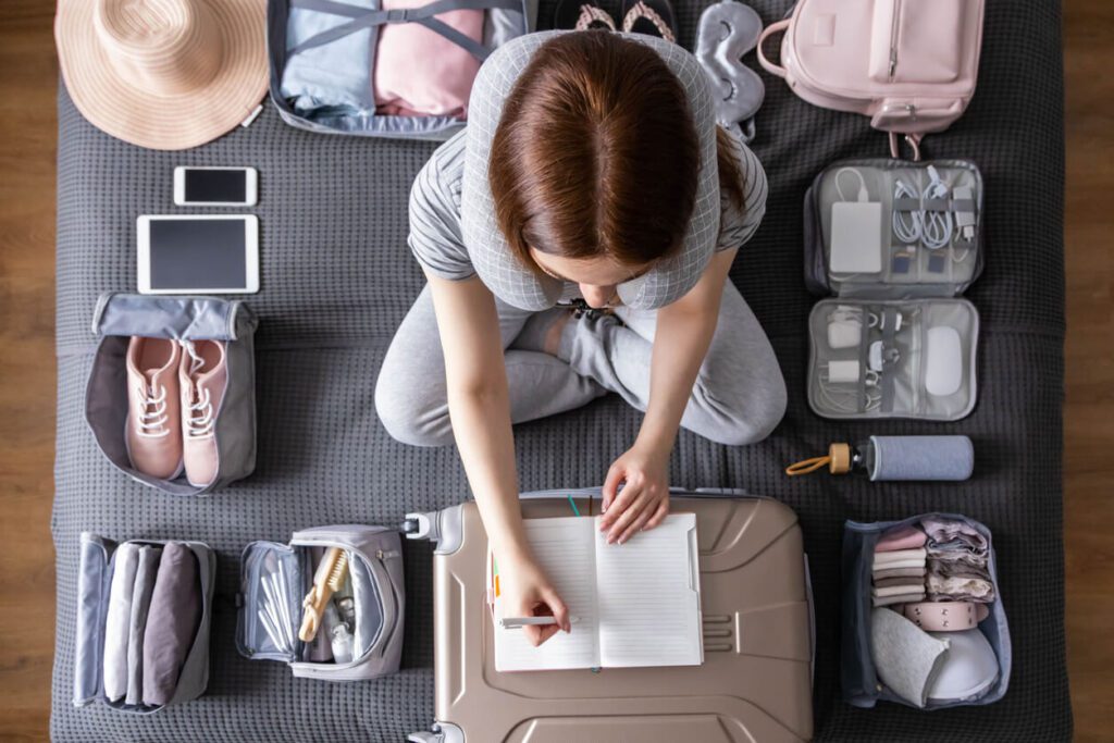 A woman sitting on the floor with her luggage.